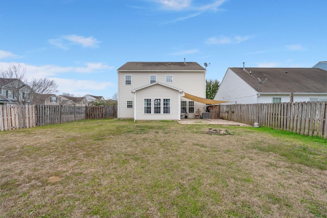 back of property with a fenced backyard, a patio, and a yard