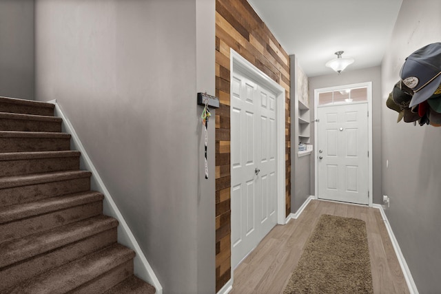 doorway to outside featuring stairs, light wood-style flooring, and baseboards