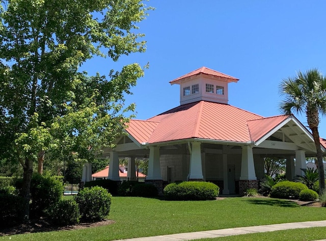 view of front of property with a standing seam roof, fence, a front yard, metal roof, and brick siding