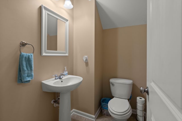 half bath featuring toilet and baseboards