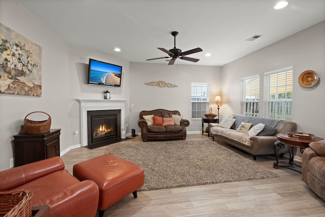 living room with visible vents, a fireplace with flush hearth, recessed lighting, light wood finished floors, and baseboards