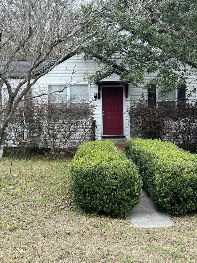 entrance to property featuring a lawn