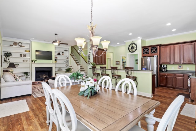 1119 Bruton Blvd, Moncks Corner, SC 29461 - dining room featuring dark wood-type flooring, ceiling fan, crown molding, a brick fireplace, and stairs