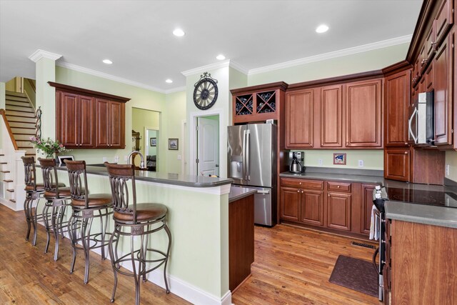 1119 Bruton Blvd, Moncks Corner, SC 29461 - kitchen featuring stainless steel appliances, a kitchen bar, light wood finished floors, recessed lighting, and dark countertops
