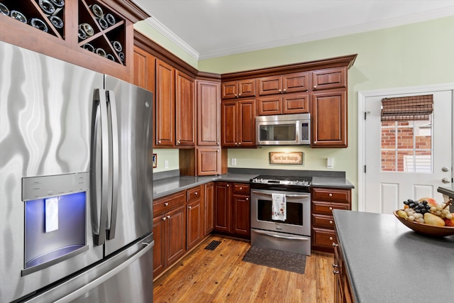 1119 Bruton Blvd, Moncks Corner, SC 29461 - kitchen featuring appliances with stainless steel finishes, dark countertops, light wood-style flooring, and crown molding