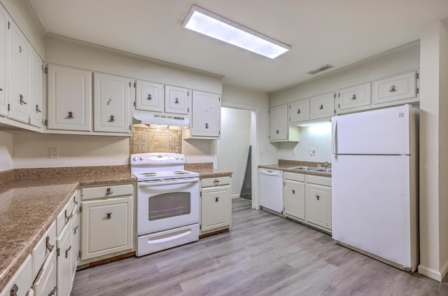 kitchen featuring white appliances, under cabinet range hood, a sink, white cabinets, and crown molding