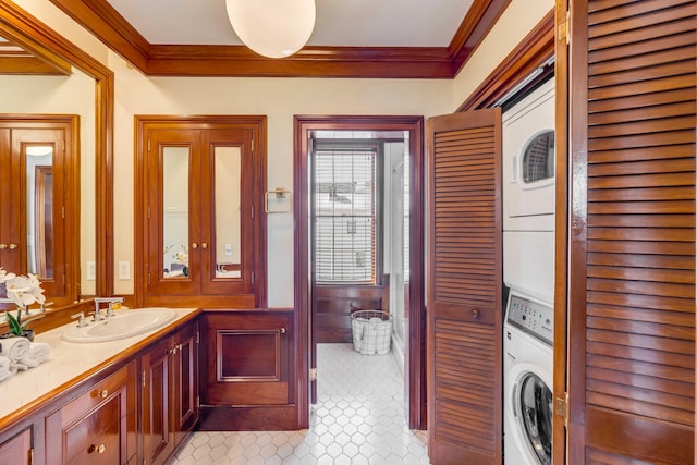 bathroom with vanity, stacked washer / drying machine, and ornamental molding