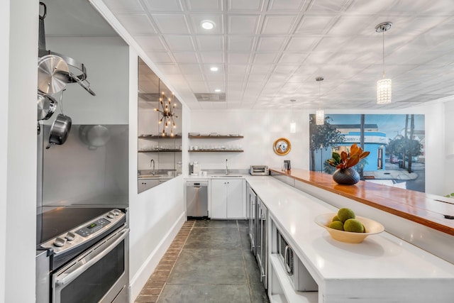 kitchen with sink, decorative light fixtures, a notable chandelier, white cabinetry, and stainless steel appliances