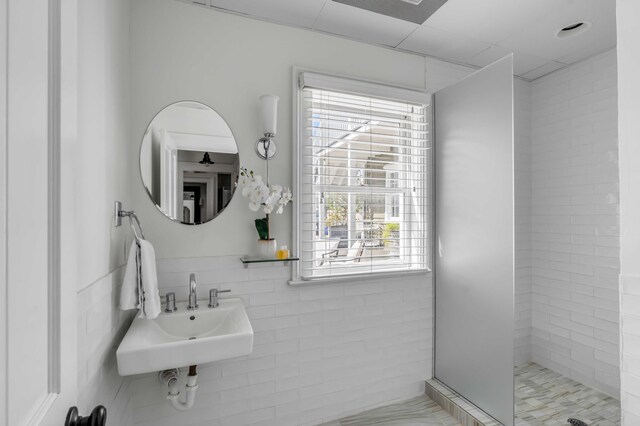 bathroom featuring tiled shower and sink