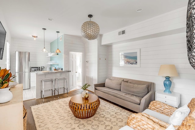 living room with wooden walls and hardwood / wood-style flooring