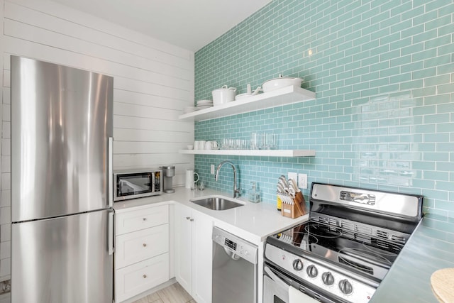 kitchen featuring backsplash, white cabinetry, sink, and appliances with stainless steel finishes