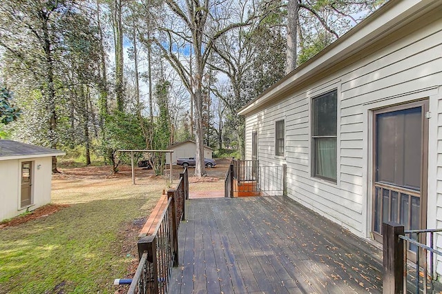 wooden deck featuring a yard, a shed, and an outdoor structure