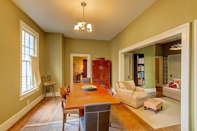 dining space featuring a notable chandelier, wood finished floors, and baseboards