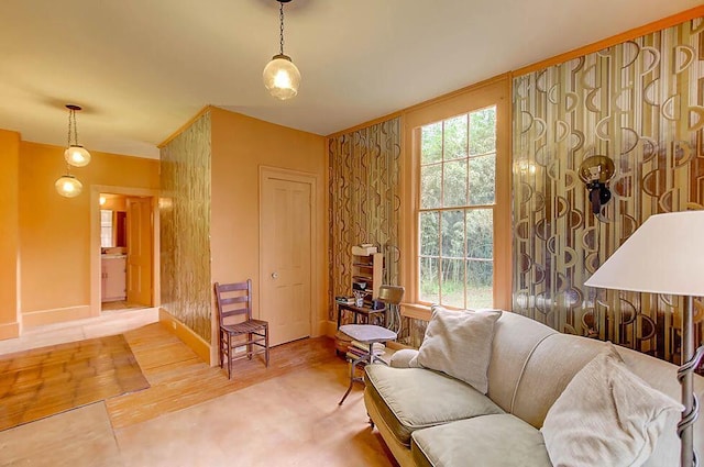 living area featuring a healthy amount of sunlight, baseboards, and wood finished floors