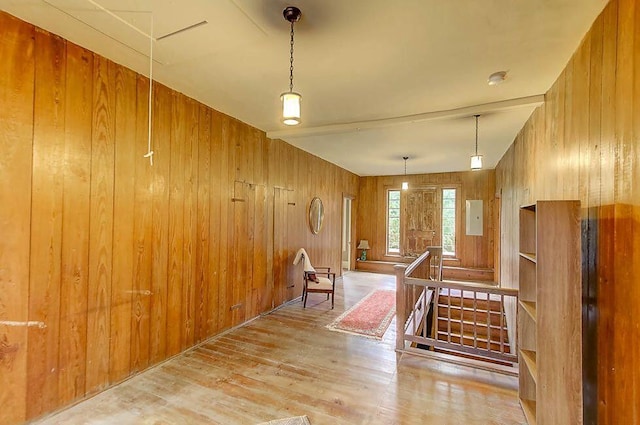 interior space with wood finished floors, attic access, an upstairs landing, and wood walls