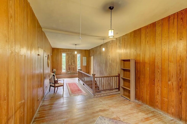 foyer entrance with wood finished floors and wood walls