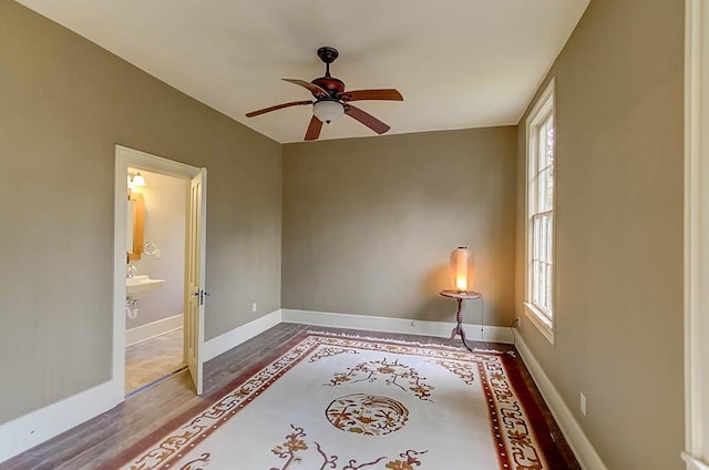 spare room featuring wood finished floors, a healthy amount of sunlight, and baseboards