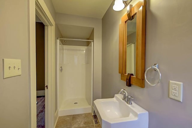 full bath with tile patterned floors, a shower, and a sink