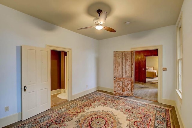 unfurnished bedroom with ceiling fan and baseboards
