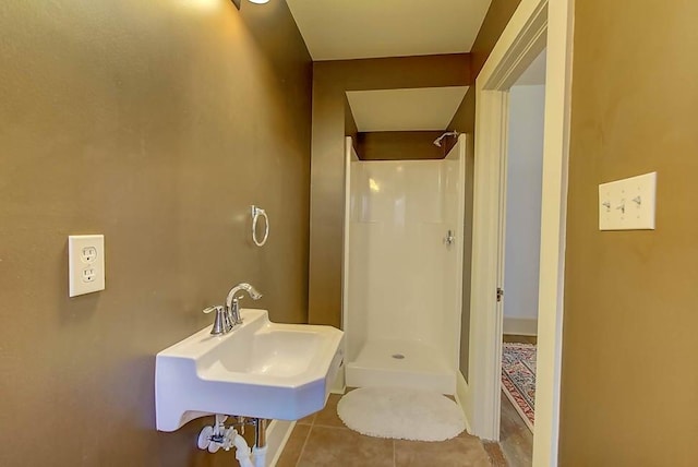 full bathroom featuring tile patterned floors, a stall shower, and a sink