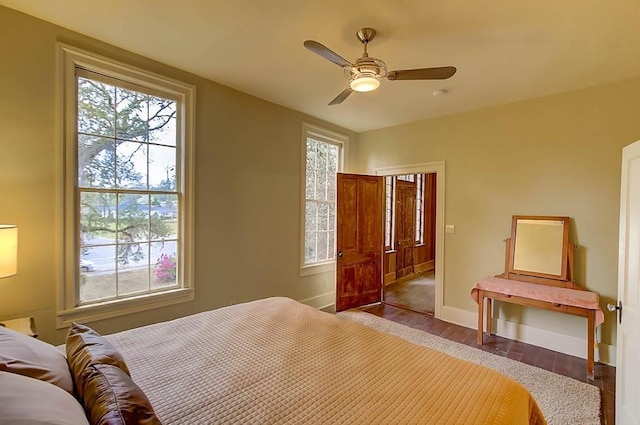 bedroom with wood finished floors, baseboards, and ceiling fan