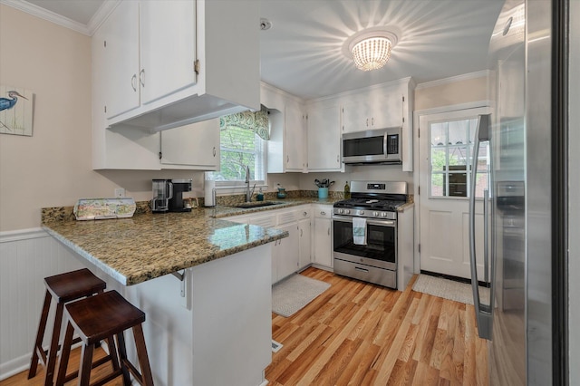 2220 Pinehurst Ave, Charleston, SC 29414 - kitchen featuring stainless steel appliances, a sink, a peninsula, ornamental molding, and light wood finished floors