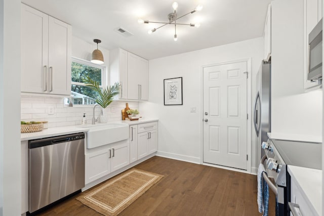 kitchen featuring appliances with stainless steel finishes, dark hardwood / wood-style floors, decorative light fixtures, white cabinetry, and sink