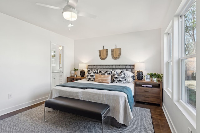 bedroom with dark wood-type flooring, ceiling fan, and connected bathroom