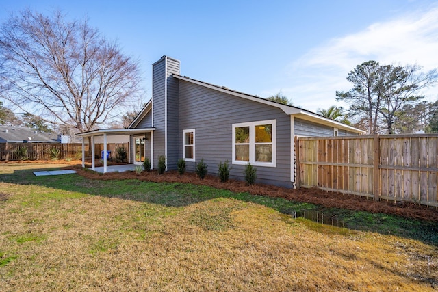 rear view of property featuring a patio and a lawn