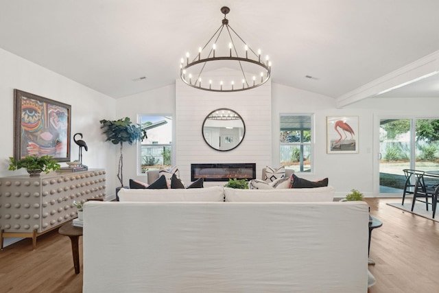 living room featuring light hardwood / wood-style flooring, a large fireplace, and vaulted ceiling