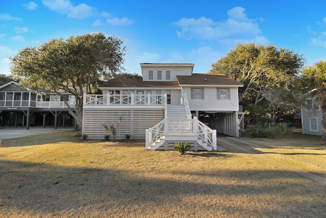 rear view of house featuring stairs, a yard, and a carport