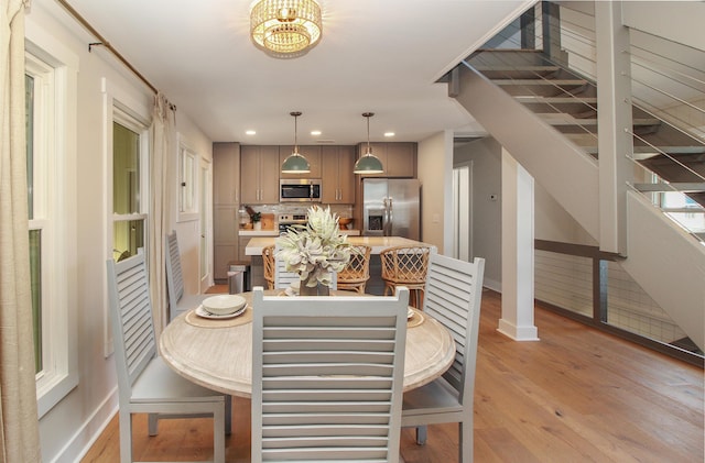 dining area with light wood finished floors, baseboards, stairway, and recessed lighting