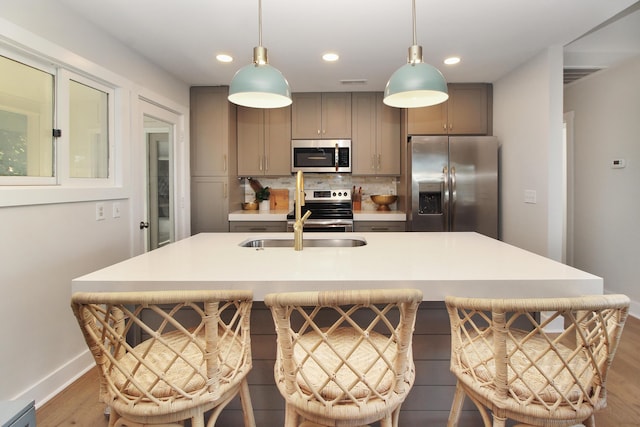 kitchen featuring tasteful backsplash, appliances with stainless steel finishes, wood finished floors, and gray cabinetry