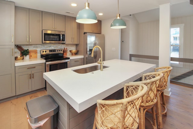 kitchen with appliances with stainless steel finishes, light wood-type flooring, visible vents, and gray cabinetry