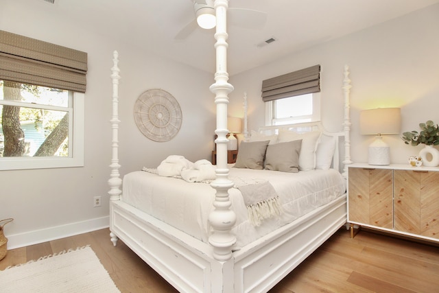 bedroom with visible vents, baseboards, and wood finished floors