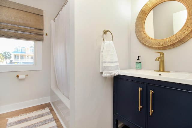 bathroom with wood finished floors, vanity, and baseboards