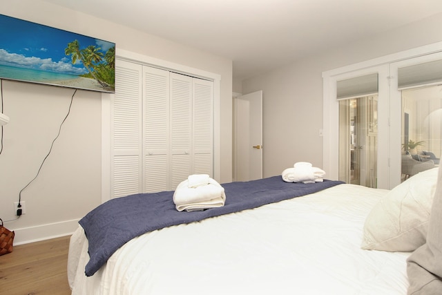 bedroom with a closet, baseboards, and wood finished floors