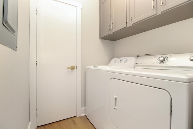 washroom with cabinet space, washer and clothes dryer, and light wood finished floors