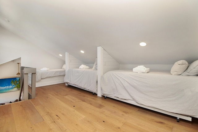 bedroom with lofted ceiling, wood finished floors, and recessed lighting