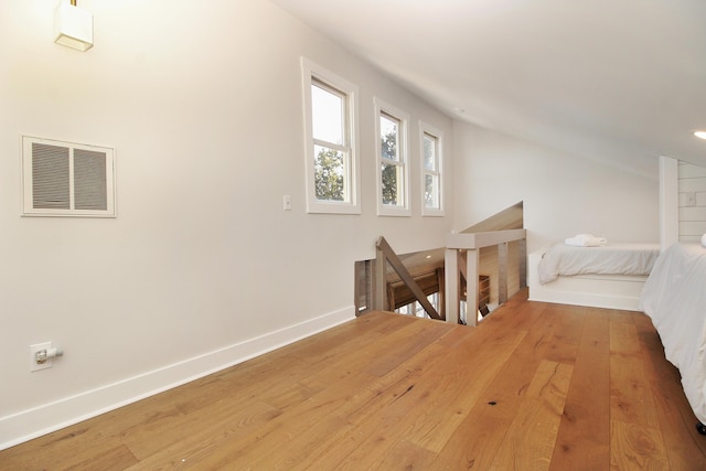 bonus room featuring hardwood / wood-style flooring, visible vents, and baseboards