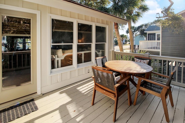 wooden deck featuring outdoor dining area and visible vents