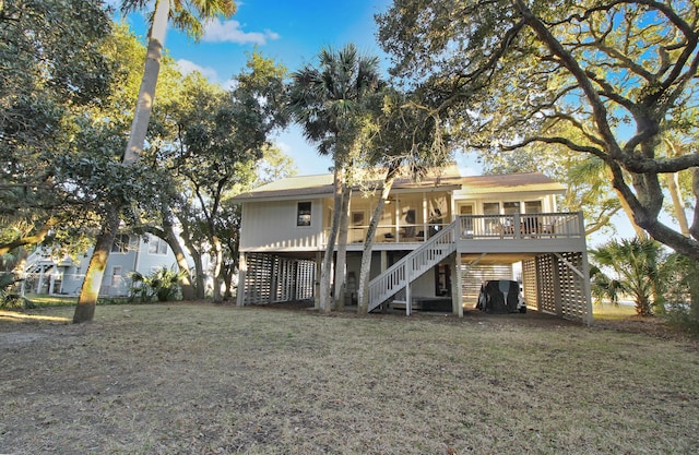 rear view of house with a yard, stairway, and a wooden deck