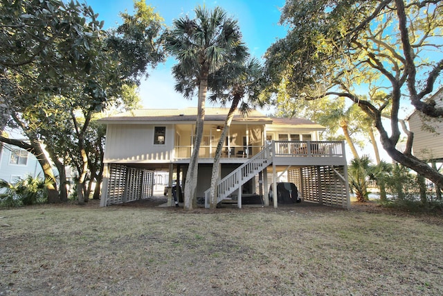 back of property featuring stairway and a lawn