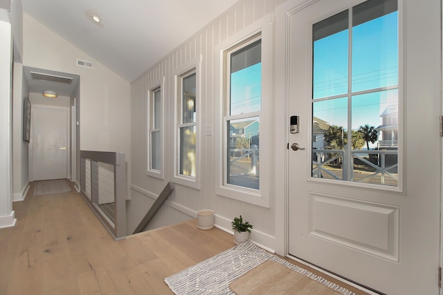 entryway with light wood-style floors, lofted ceiling, visible vents, and baseboards