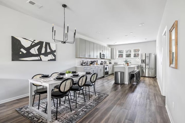 dining space featuring a chandelier, dark wood-type flooring, baseboards, and recessed lighting