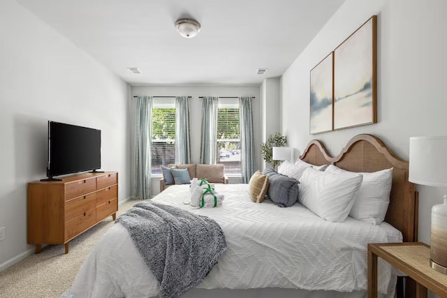 bedroom featuring light carpet and baseboards