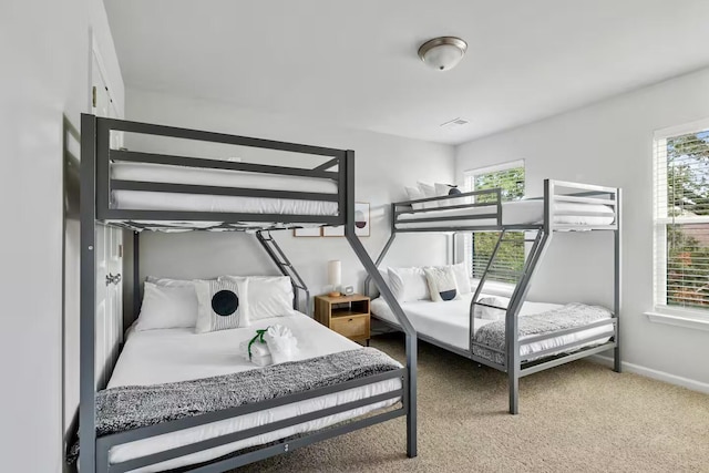 carpeted bedroom with multiple windows and baseboards