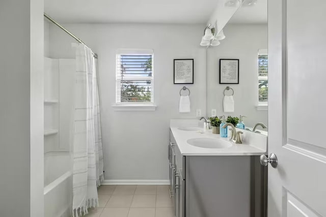 full bathroom featuring baseboards, double vanity, tile patterned flooring, and shower / bath combo with shower curtain