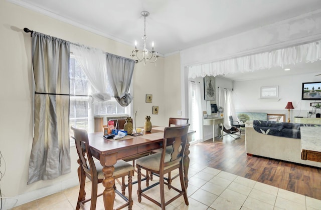 tiled dining space with a chandelier and crown molding