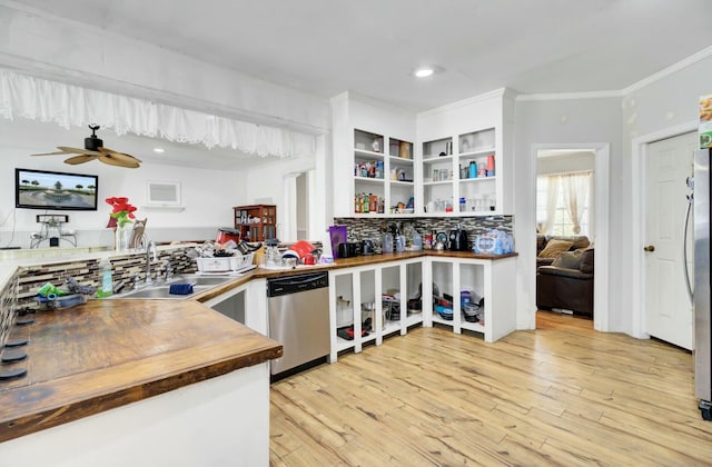 kitchen with light wood-type flooring, ornamental molding, a sink, appliances with stainless steel finishes, and butcher block counters